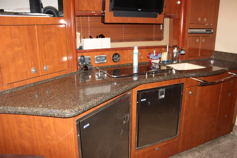 Slide: The Image of Luxurious 2006 Sea Ray 40 Sundancer yacht kitchen with sleek wood cabinetry and modern appliances. - 28