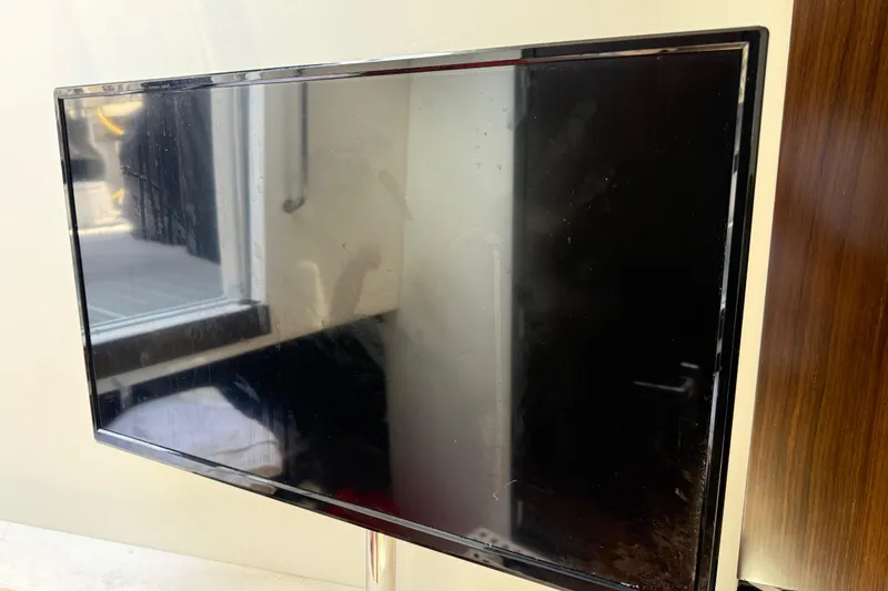 Slide: The Image of Flat-screen TV mounted on a wall inside a 2021 Cruisers Yachts 38 GLS OB. - 61