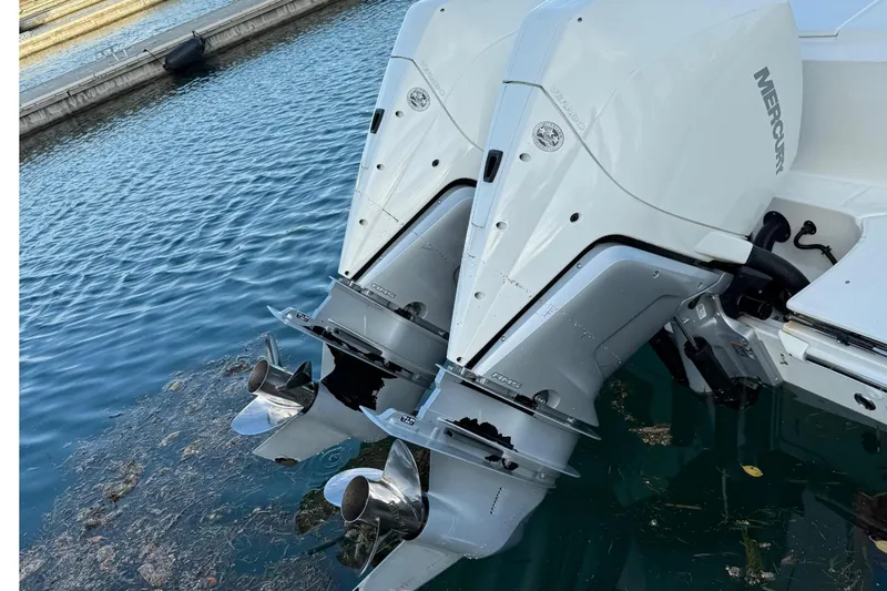Slide: The Image of 2020 Boston Whaler 330 Outrage with dual outboard engines docked in marina. - 6