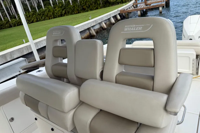 Slide: The Image of 2020 Boston Whaler 330 Outrage boat seats, luxurious beige leather, dockside view. - 12