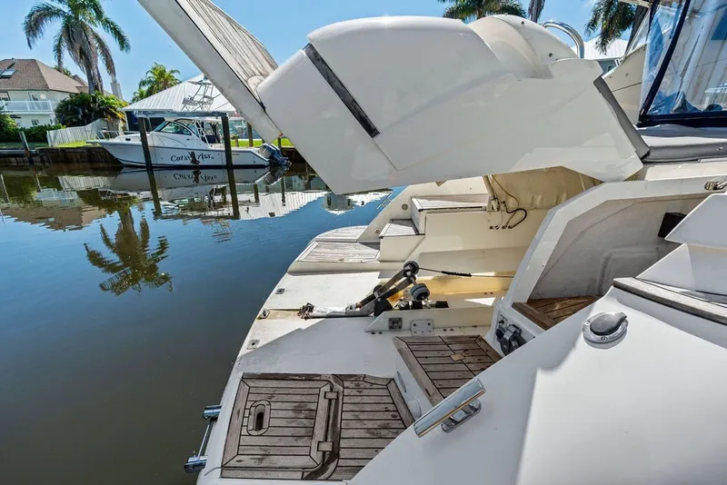 Slide: The Image of 2006 Fairline Targa 47 GT yacht with open deck, docked by palm trees. - 26