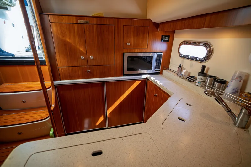 Slide: The Image of The galley of a 2006 Tiara Yachts 4400 Sovran with wooden cabinets and a microwave. - 45