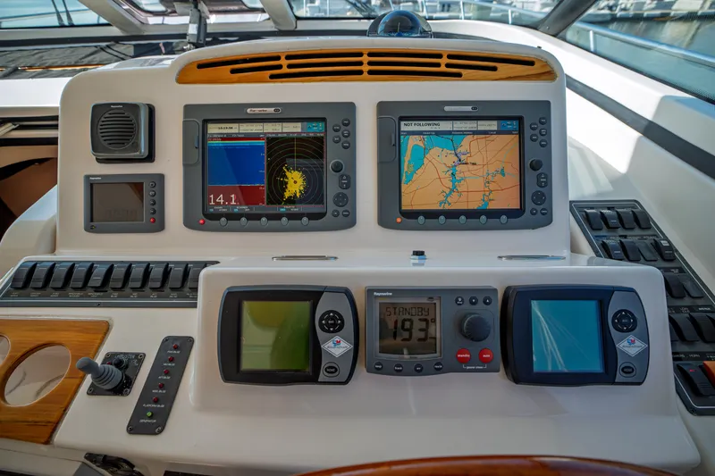 Slide: The Image of The image shows the dashboard of a 2006 Tiara Yachts 4400 Sovran with multiple navigation screens. - 16
