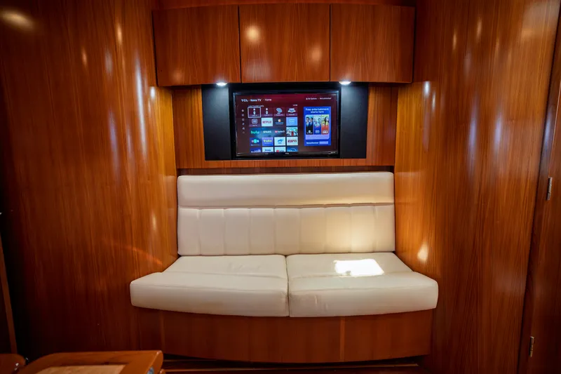 Slide: The Image of Interior of a 2006 Tiara Yachts 4400 Sovran with a white sofa and built-in TV. - 36