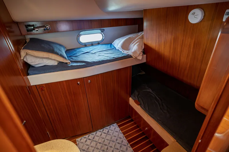 Slide: The Image of The 2006 Tiara Yachts 4400 Sovran cabin features two bunk beds and wooden walls. - 27