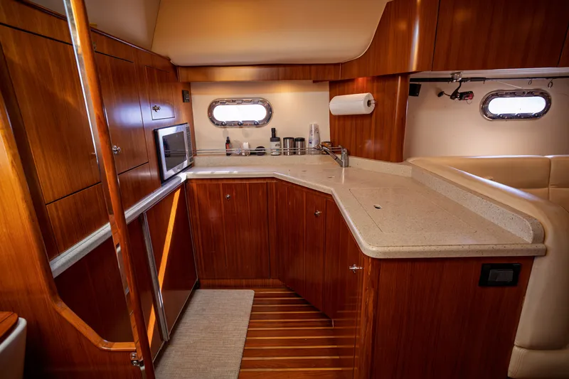 Slide: The Image of The 2006 Tiara Yachts 4400 Sovran's kitchen features wooden cabinets and a countertop. - 35