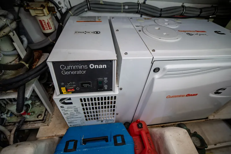 Slide: The Image of A Cummins Onan generator in an engine room, surrounded by hoses and cables. - 46