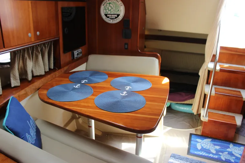 Slide: The Image of 2007 Cruisers Yachts 340 Express interior with wooden table and blue placemats. - 46