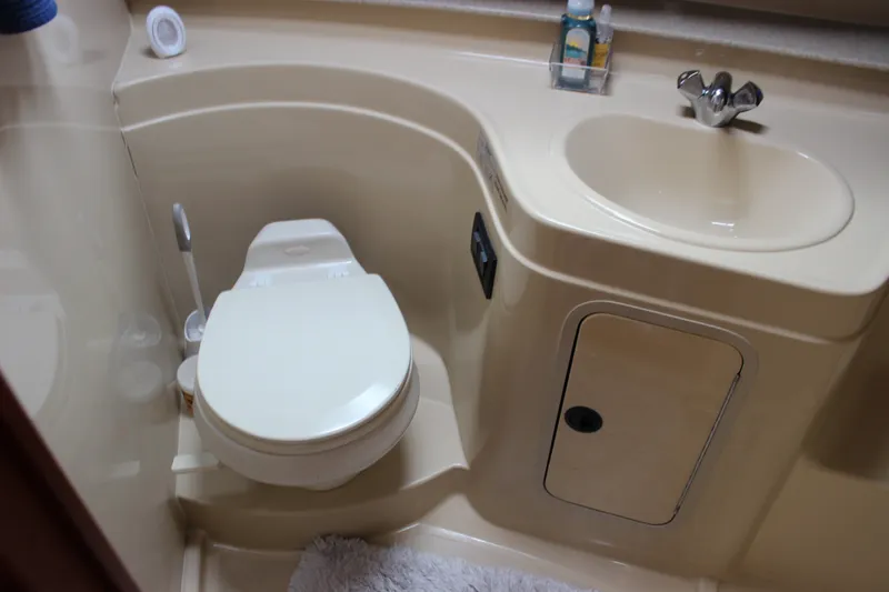 Slide: The Image of 2007 Cruisers Yachts 340 Express bathroom with toilet, sink, and storage cabinet. - 41