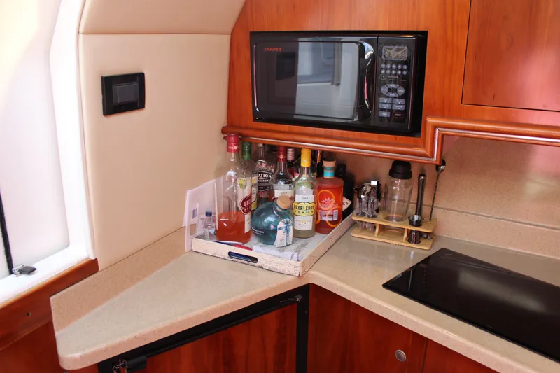 Slide: The Image of 2007 Cruisers Yachts 340 Express galley with microwave, countertop, and beverage tray. - 29