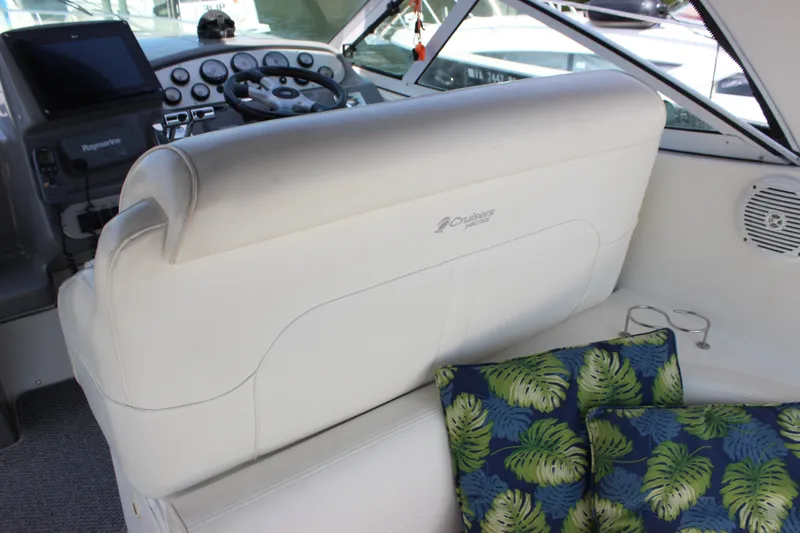 Slide: The Image of 2007 Cruisers Yachts 340 Express cockpit with white seating and tropical cushions. - 12