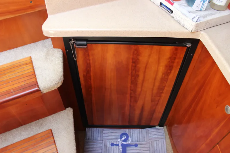 Slide: The Image of Interior of 2007 Cruisers Yachts 340 Express, featuring wooden cabinetry and carpeted steps. - 51