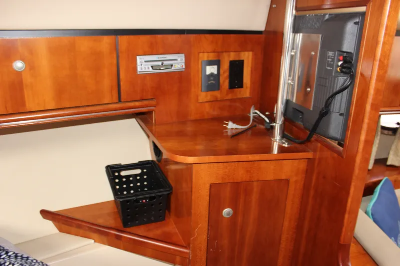 Slide: The Image of 2007 Cruisers Yachts 340 Express interior with wooden cabinetry and built-in electronics. - 45