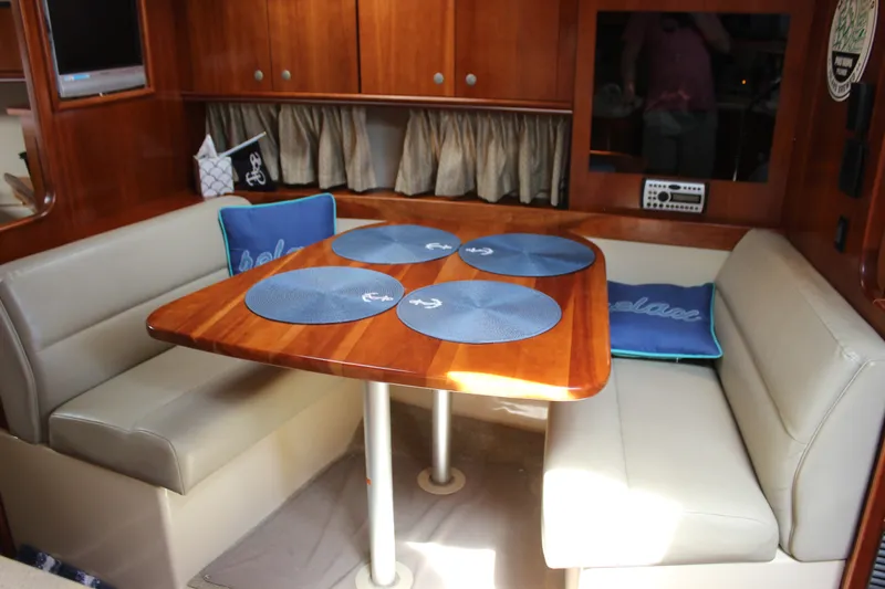 Slide: The Image of 2007 Cruisers Yachts 340 Express interior with dining area, wooden table, and cushioned seating. - 37