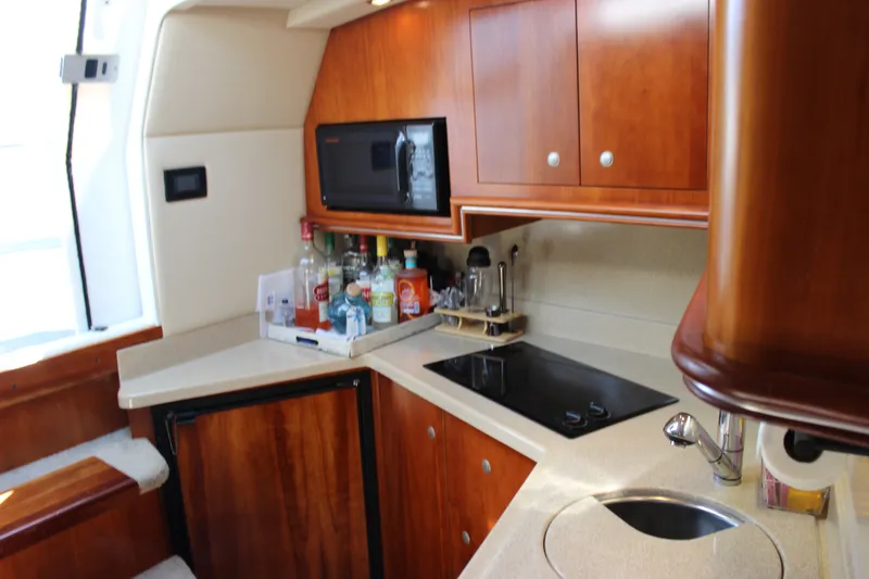 Slide: The Image of Luxurious 2007 Cruisers Yachts 340 Express galley with modern amenities and wooden cabinetry. - 48