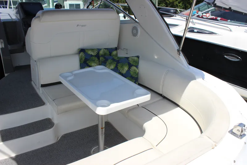 Slide: The Image of 2007 Cruisers Yachts 340 Express interior with white seating and table, featuring tropical cushions. - 10