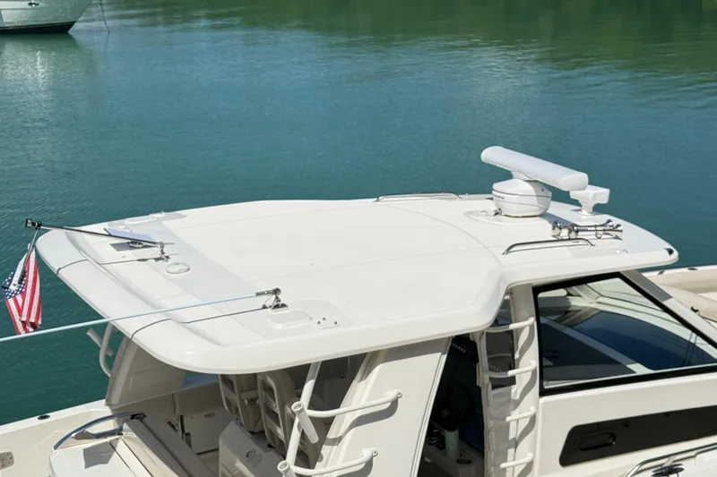 Slide: The Image of 2017 Boston Whaler 420 Outrage boat on calm water, featuring radar and American flag. - 15