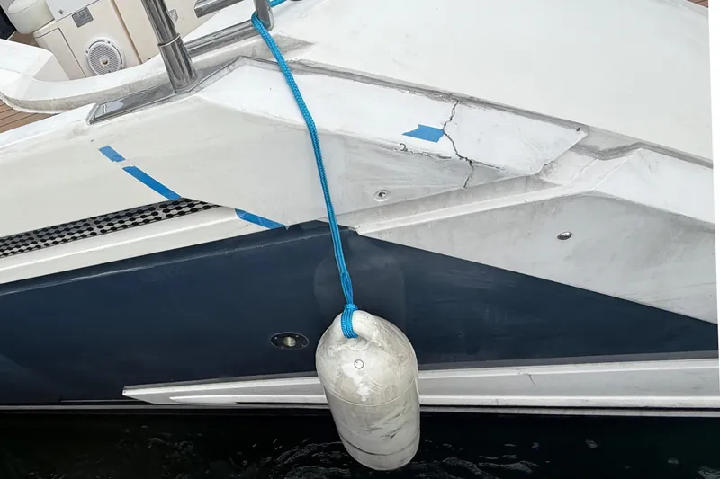 Slide: The Image of 2012 Fairline Targa 58 yacht with visible hull damage and a hanging fender. - 81