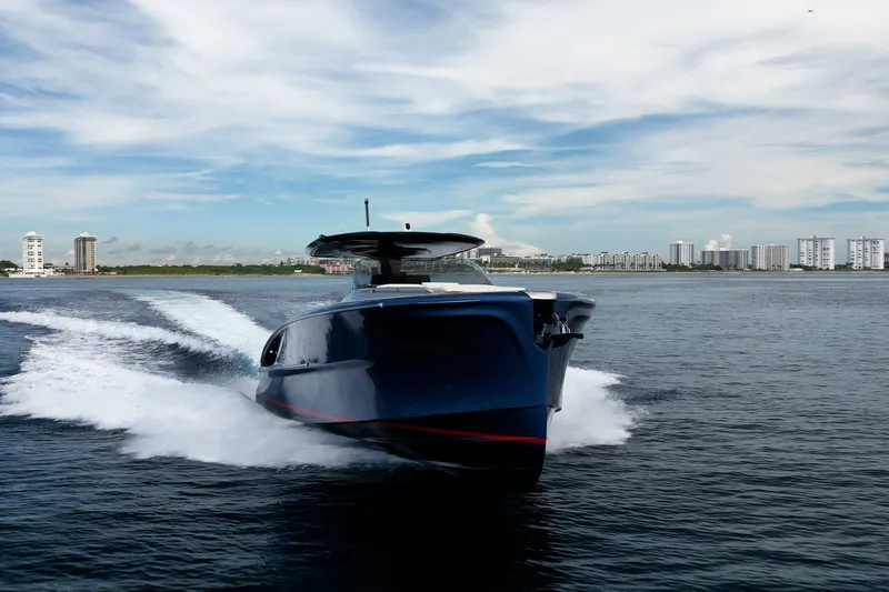 Slide: The Image of 2024 Solaris Power 40F Open yacht cruising on open water with city skyline backdrop. - 49