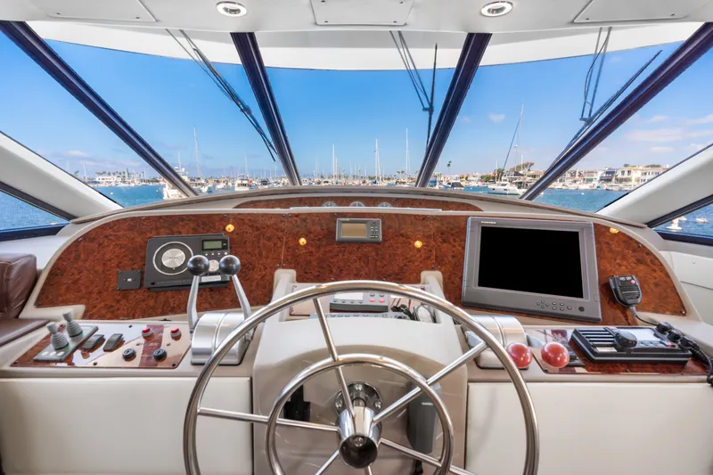 Slide: The Image of 2001 Bayliner 5788 Pilot House Motoryacht helm with navigation equipment and marina view. - 25