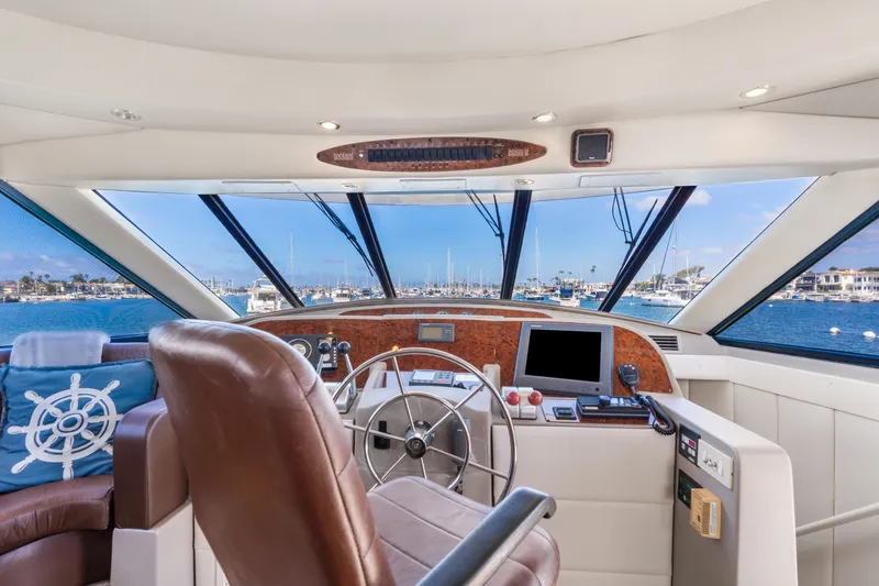 Slide: The Image of Interior view of 2001 Bayliner 5788 Pilot House Motoryacht helm with marina backdrop. - 23