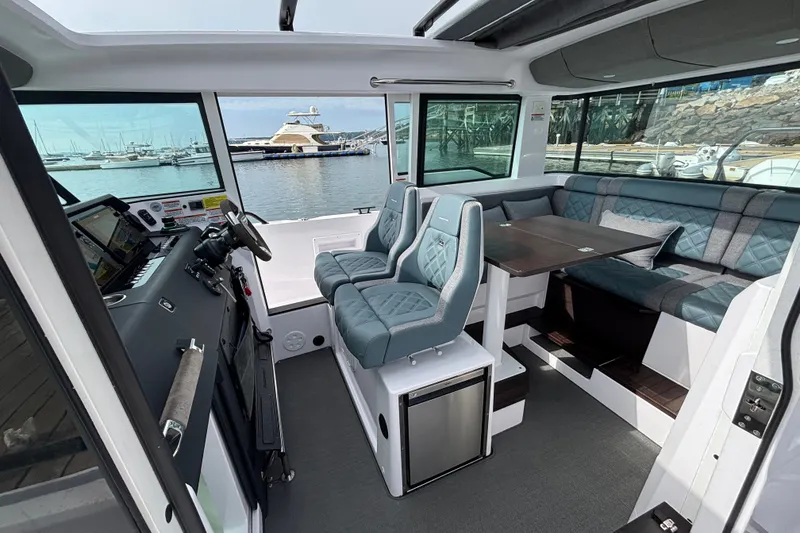 Slide: The Image of Interior of 2024 Axopar 37 XC Cross Cabin with seating and helm, docked at marina. - 20