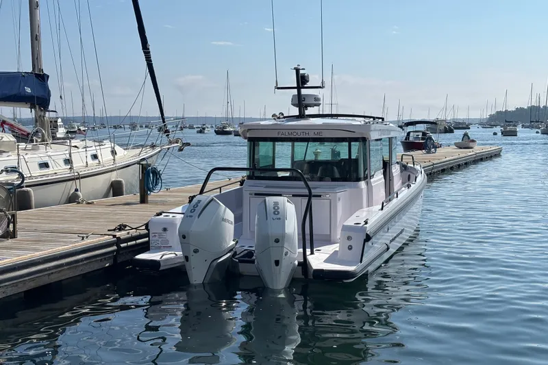 Slide: The Image of 2024 Axopar 37 XC Cross Cabin docked in a marina with twin engines. - 3