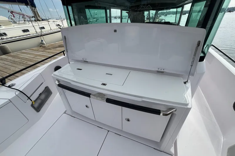 Slide: The Image of 2024 Axopar 37 XC Cross Cabin boat interior with sleek white cabinetry. - 12