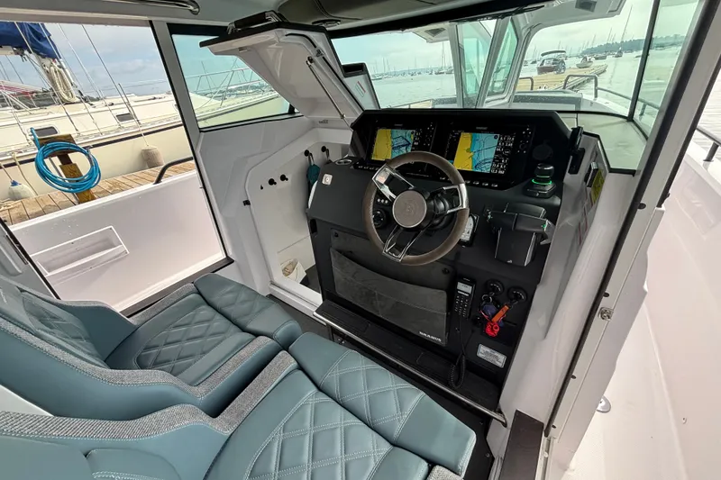 Slide: The Image of 2024 Axopar 37 XC Cross Cabin helm with dual screens and leather seats. - 23