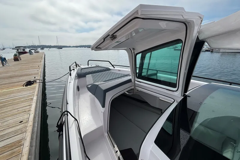 Slide: The Image of 2024 Axopar 37 XC Cross Cabin docked, showcasing open cabin and sleek design. - 31