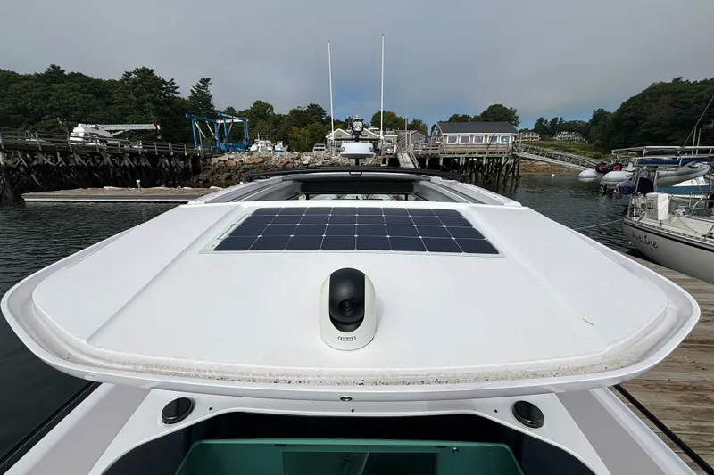 Slide: The Image of 2024 Axopar 37 XC Cross Cabin with solar panel, docked at a marina. - 34