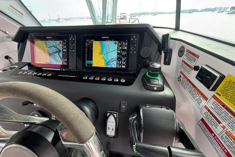 Slide: The Image of 2024 Axopar 37 XC Cross Cabin helm with dual Simrad displays and navigation controls. - 24