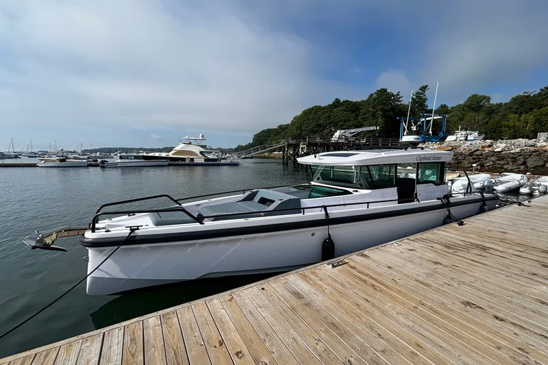 Slide: The Image of 2024 Axopar 37 XC Cross Cabin docked at a marina, surrounded by boats. - 1
