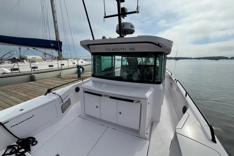 Slide: The Image of 2024 Axopar 37 XC Cross Cabin docked, showcasing sleek design and spacious deck. - 11