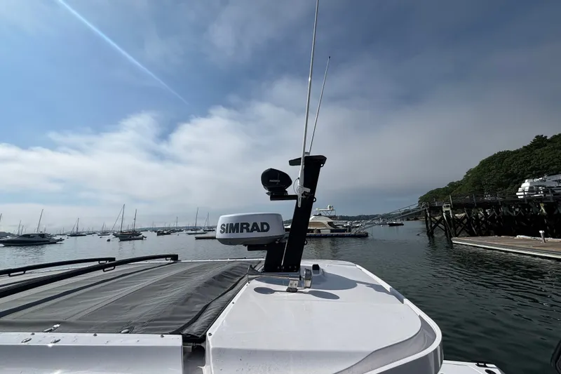 Slide: The Image of 2024 Axopar 37 XC Cross Cabin boat with Simrad equipment, docked in a scenic marina. - 35