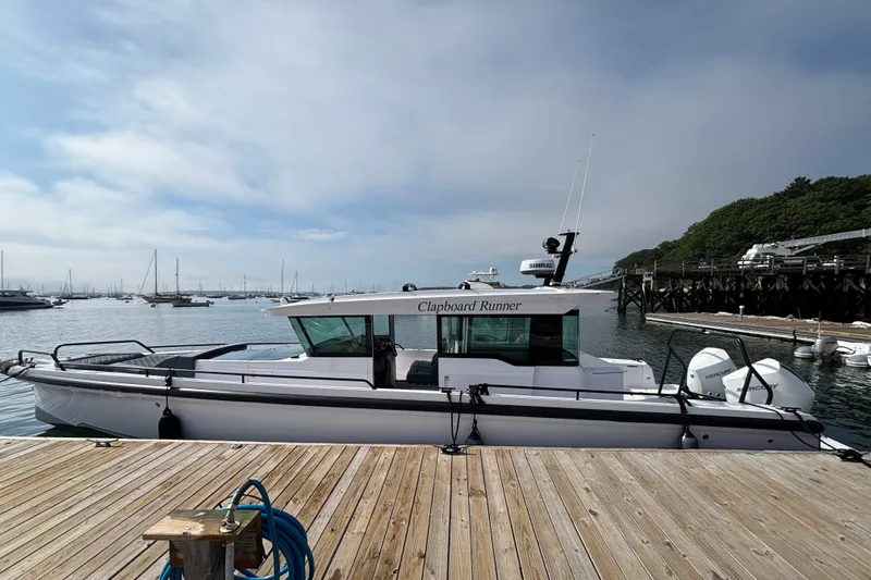 Slide: The Image of 2024 Axopar 37 XC Cross Cabin docked at a marina with scenic background. - 8