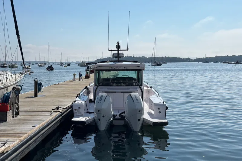 Slide: The Image of 2024 Axopar 37 XC Cross Cabin docked at a marina, surrounded by calm waters. - 6