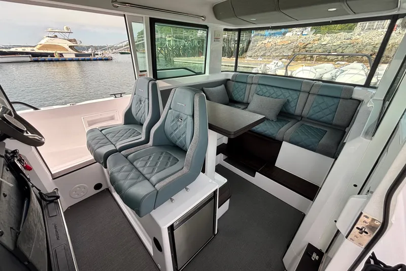 Slide: The Image of 2024 Axopar 37 XC Cross Cabin interior with luxurious seating and waterfront view. - 16