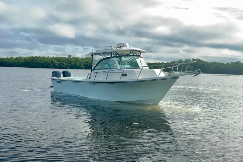 Slide: The Image of 2017 Parker 2810 XLD Walkaround boat cruising on calm water under cloudy skies. - 19