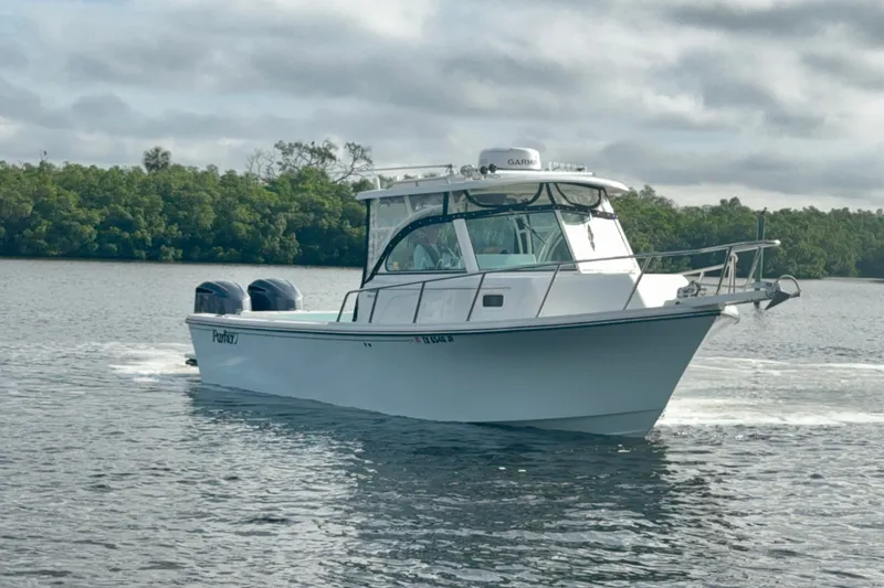 Slide: The Image of 2017 Parker 2810 XLD Walkaround boat cruising on calm water near lush greenery. - 22