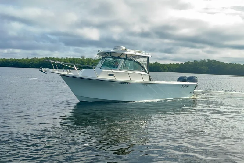 Slide: The Image of 2017 Parker 2810 XLD Walkaround boat cruising on calm water under cloudy skies. - 21