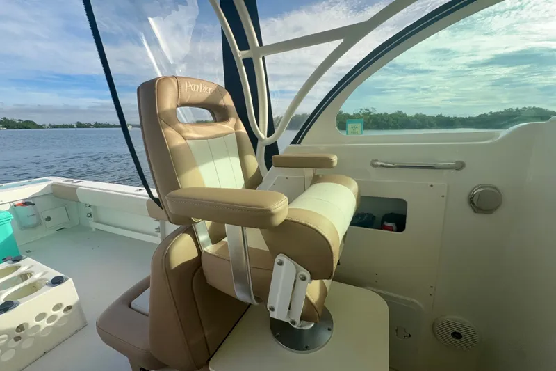 Slide: The Image of 2017 Parker 2810 XLD Walkaround boat interior with tan seating and scenic water view. - 9