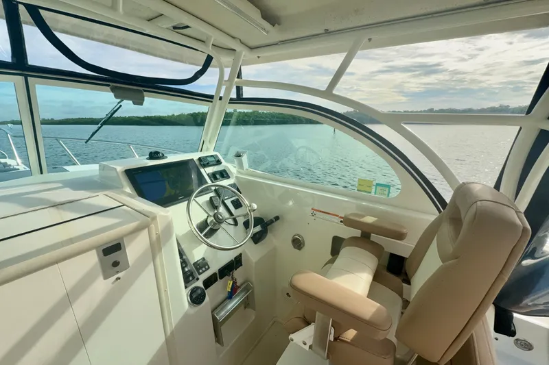 Slide: The Image of 2017 Parker 2810 XLD Walkaround boat interior with steering wheel and navigation system. - 2