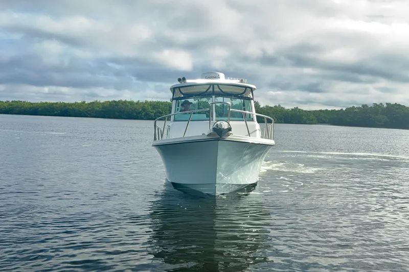 Slide: The Image of 2017 Parker 2810 XLD Walkaround boat cruising on calm water under cloudy skies. - 20