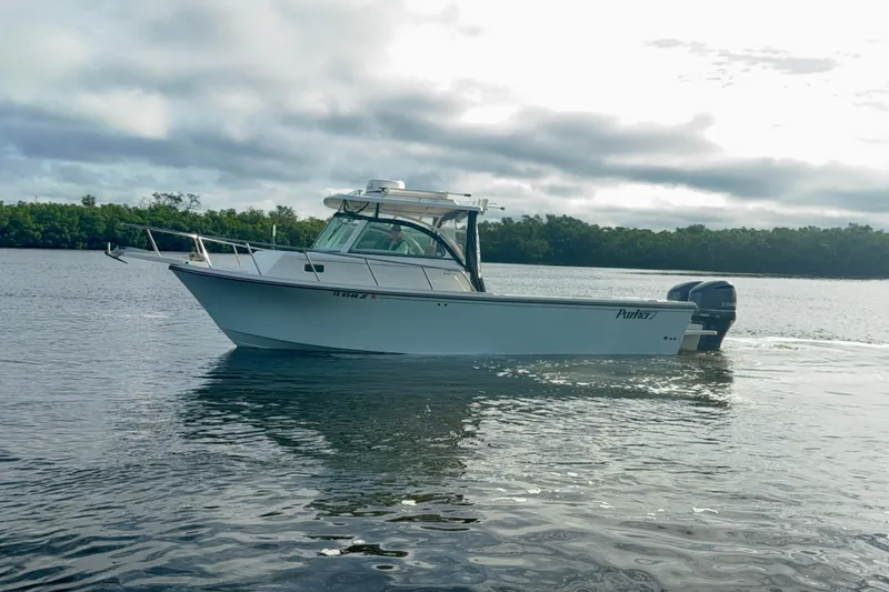 Slide: The Image of 2017 Parker 2810 XLD Walkaround boat on calm water under cloudy sky. - 18