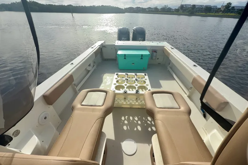 Slide: The Image of 2017 Parker 2810 XLD Walkaround boat interior with seating and storage on a calm lake. - 12
