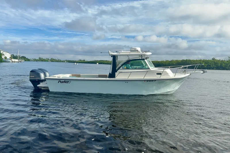 Slide: The Image of 2017 Parker 2810 XLD Walkaround boat on calm water under a cloudy sky. - 16