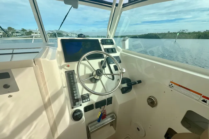Slide: The Image of 2017 Parker 2810 XLD Walkaround boat helm with steering wheel and navigation controls. - 5
