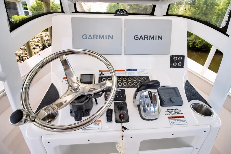 Slide: The Image of 2021 Blue Wave 2800 Makaira boat helm with Garmin displays and controls. - 31