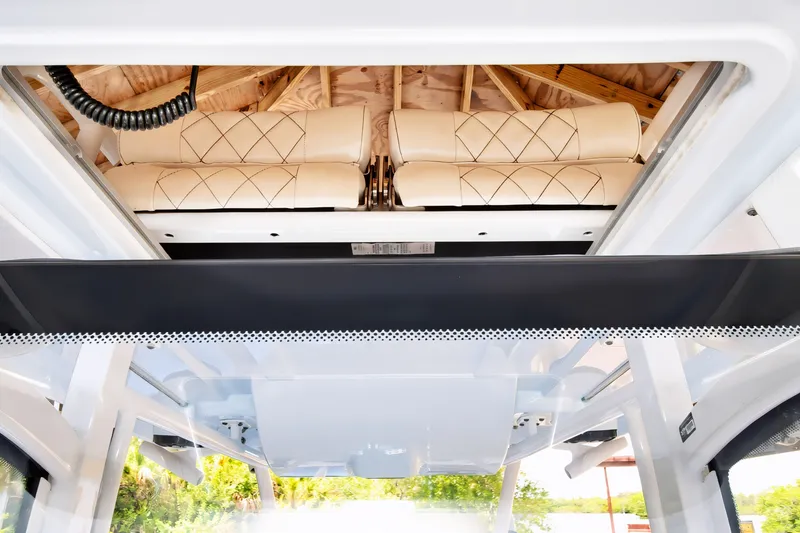 Slide: The Image of 2021 Blue Wave 2800 Makaira boat interior with cushioned seating and overhead storage. - 50